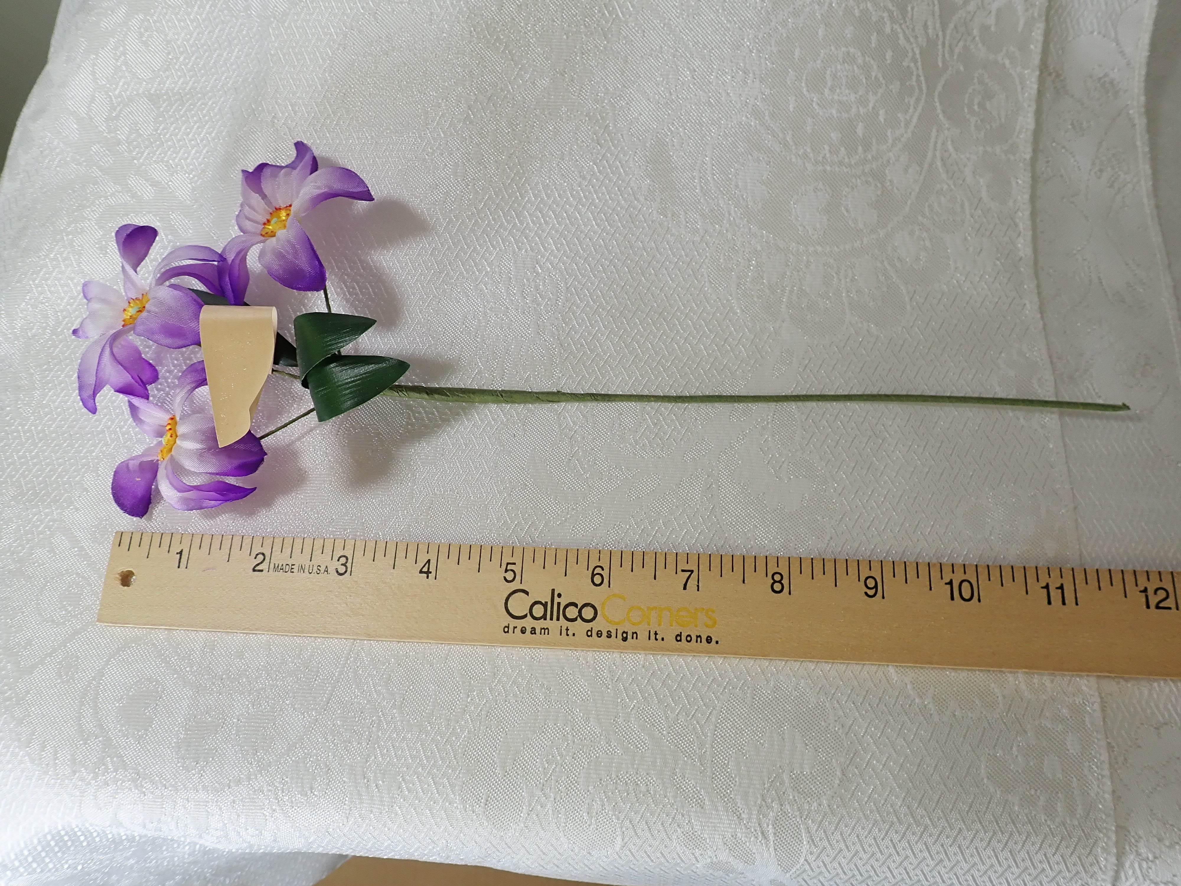 Six stems of Vintage millinery flowers. Purple anemones with yellow center and green leaves.